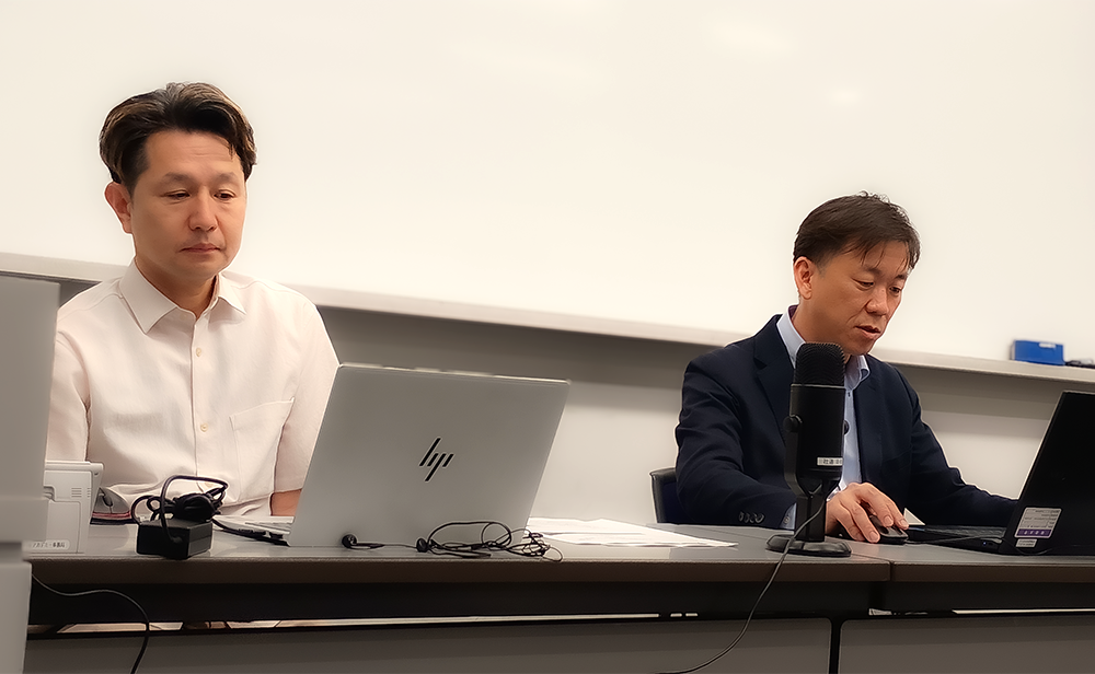 会場の席に着く新井先生とSCSK 杉岡の写真